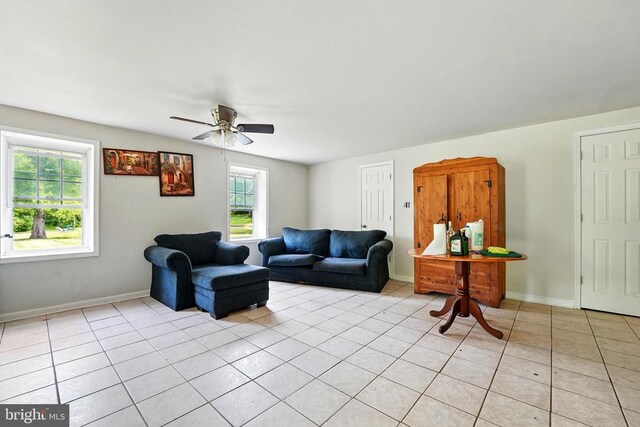  - living room featuring a ceiling fan, light tile patterned floors, and baseboards