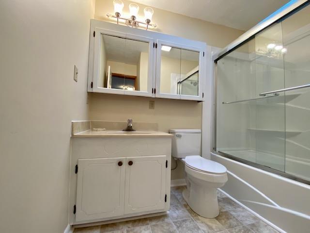 1655 Howardsville Tpke, Stuarts Draft, VA 24477 - full bathroom with toilet, baseboards, vanity, and bath / shower combo with glass door
