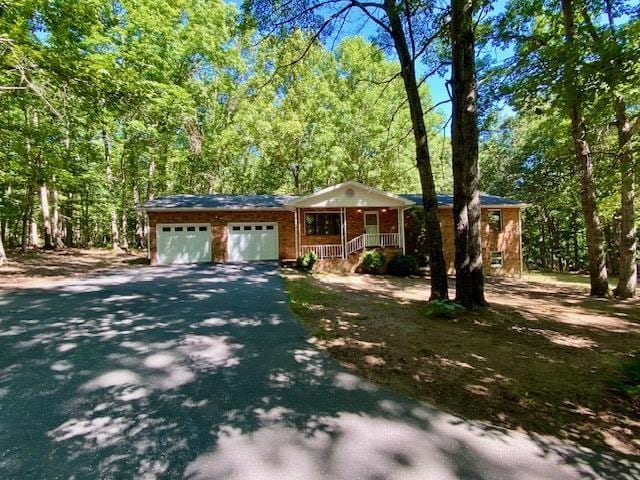 1655 Howardsville Tpke, Stuarts Draft, VA 24477 - view of front of home featuring driveway, a porch, a view of trees, and a garage
