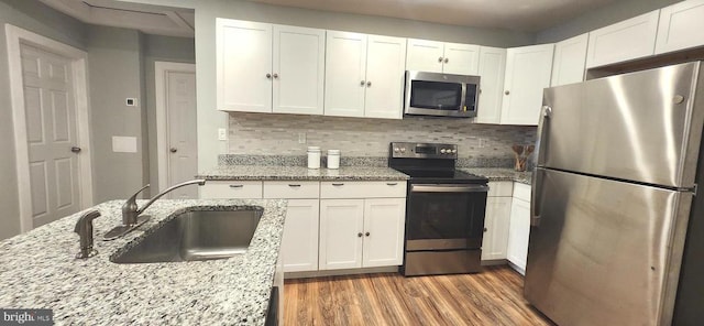 320 Third St, Fredericksburg, VA 22408 - kitchen featuring appliances with stainless steel finishes, white cabinets, wood finished floors, and backsplash