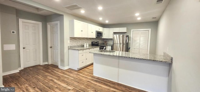 320 Third St, Fredericksburg, VA 22408 - kitchen with stainless steel appliances, light stone counters, backsplash, wood finished floors, and white cabinets