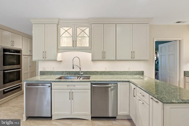 kitchen featuring a sink, appliances with stainless steel finishes, a warming drawer, and stone countertops