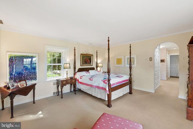 bedroom with carpet flooring, crown molding, arched walkways, and baseboards