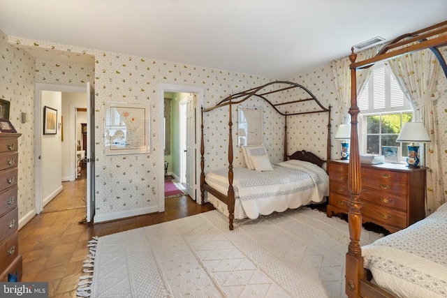 bedroom featuring wallpapered walls and baseboards