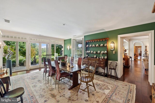 dining space with crown molding, hardwood / wood-style floors, and french doors