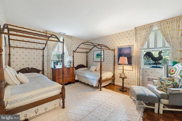 bedroom featuring wallpapered walls, baseboards, and wood finished floors