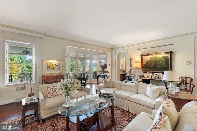 living room with plenty of natural light, crown molding, wood finished floors, and french doors