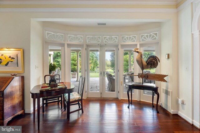 doorway with french doors, dark wood finished floors, baseboards, and crown molding