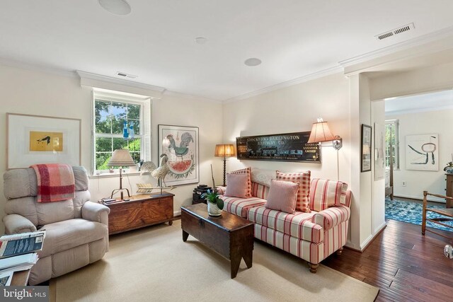 living room featuring ornamental molding, hardwood / wood-style floors, and baseboards
