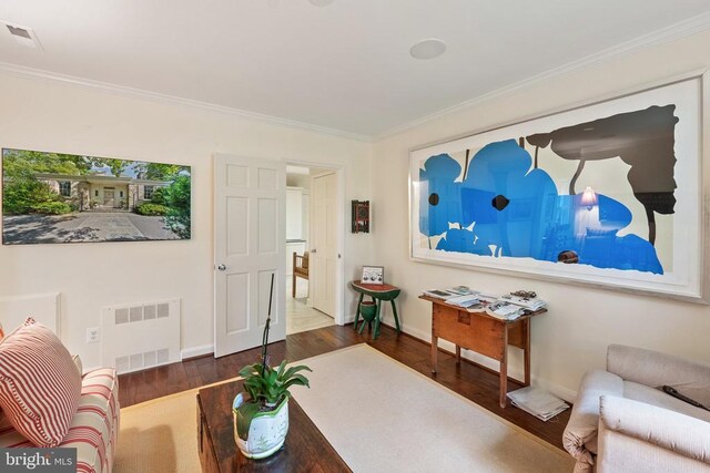 living area featuring wood finished floors, ornamental molding, and baseboards
