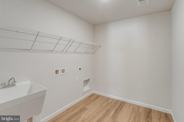 35607 Pine Needle Ln, Locust Grove, VA 22508 - laundry room with hookup for an electric dryer, light wood-style flooring, hookup for a washing machine, and baseboards