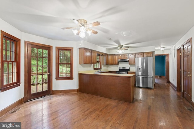  - kitchen with stainless steel appliances, under cabinet range hood, a peninsula, and dark wood-style floors