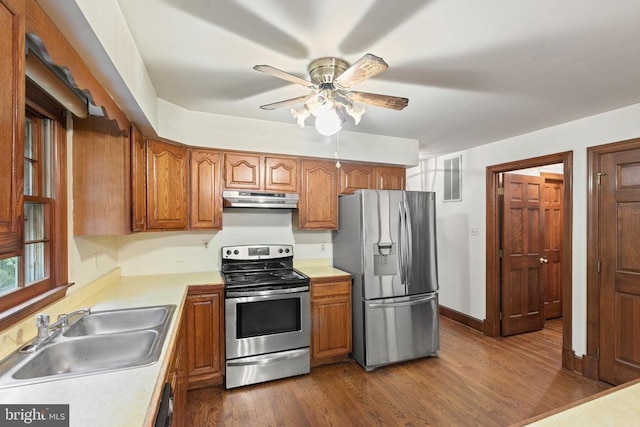  - kitchen featuring stainless steel appliances, under cabinet range hood, light countertops, dark wood-style floors, and a ceiling fan