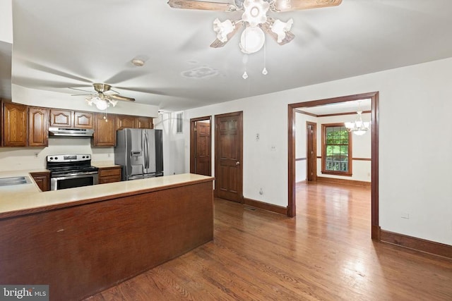  - kitchen with appliances with stainless steel finishes, a ceiling fan, under cabinet range hood, and wood finished floors
