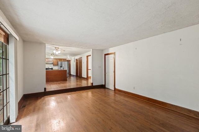  - unfurnished living room with dark wood-type flooring and a textured ceiling