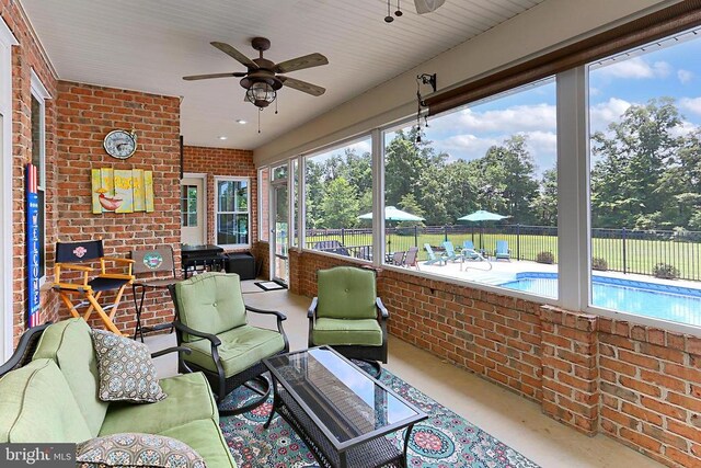  - sunroom / solarium featuring outdoor lounge area, ceiling fan, brick wall, and healthy amount of natural light