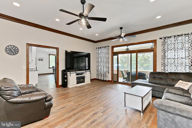  - living area featuring crown molding, a ceiling fan, light wood-style flooring, recessed lighting, and a fireplace