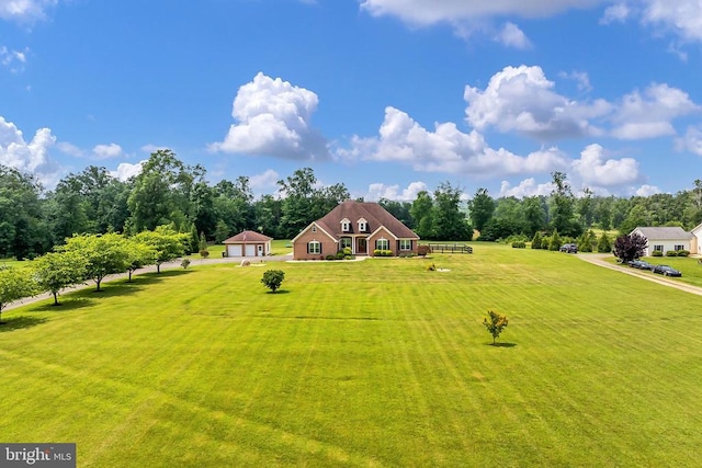  - view of front of house with a garage, a front lawn, and view of scattered trees