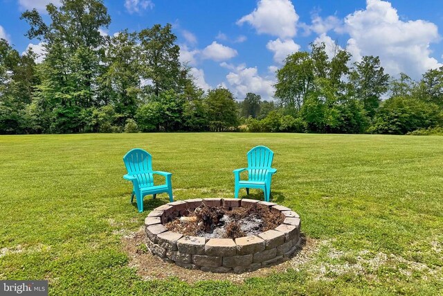  - view of grassy yard with an outdoor fire pit