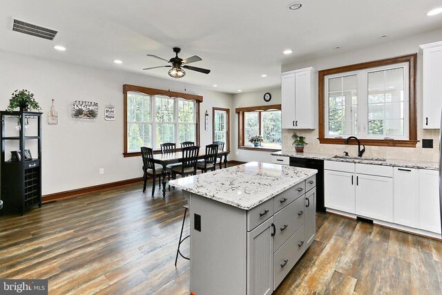  - kitchen featuring ceiling fan, dark wood-style floors, a breakfast bar area, recessed lighting, and a kitchen island
