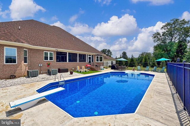  - view of swimming pool with a patio and a diving board