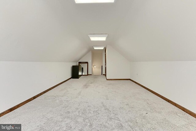  - additional living space featuring light colored carpet, lofted ceiling, and a skylight