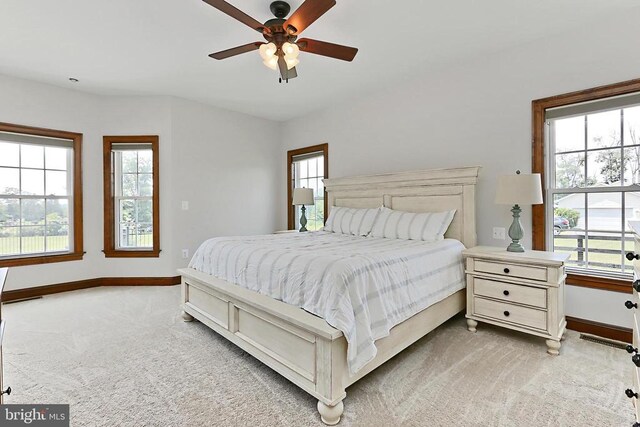 - bedroom with multiple windows, light colored carpet, and ceiling fan