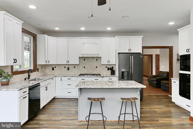  - kitchen featuring black appliances, custom range hood, dark wood finished floors, white cabinets, and recessed lighting