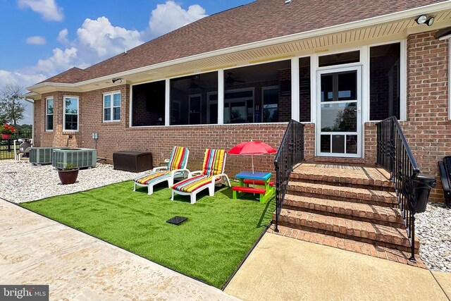  - rear view of property with brick siding, roof with shingles, and a yard