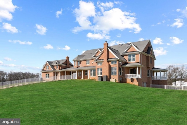 back of house featuring a chimney, central air condition unit, and brick siding