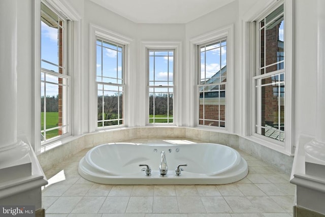bathroom with healthy amount of natural light, a bath, and tile patterned floors