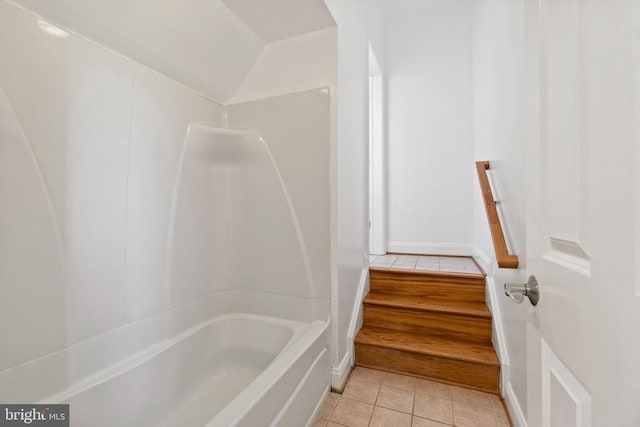 bathroom with tile patterned flooring, lofted ceiling, and tub / shower combination