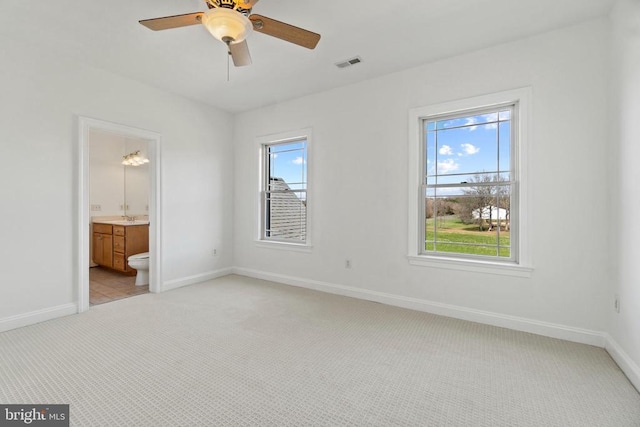 unfurnished bedroom with light carpet, multiple windows, and baseboards