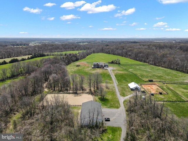 aerial view of sparsely populated area featuring a pastoral area and a heavily wooded area