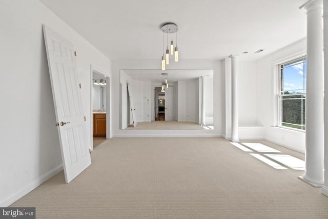 unfurnished dining area with light colored carpet, decorative columns, and baseboards
