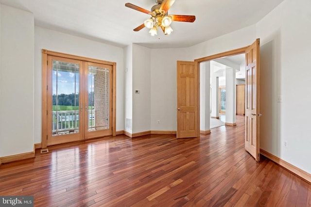 spare room with hardwood / wood-style flooring, a ceiling fan, baseboards, and french doors
