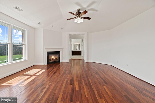 unfurnished living room featuring plenty of natural light, a ceiling fan, a glass covered fireplace, wood finished floors, and lofted ceiling