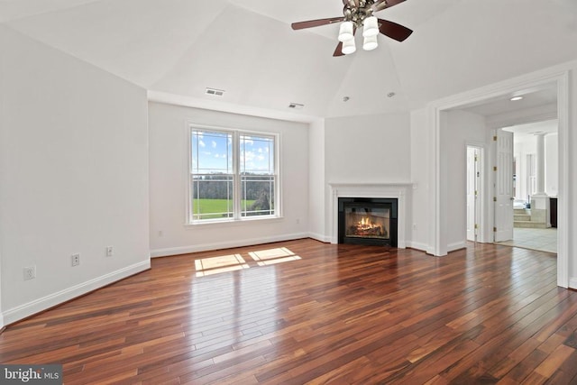 unfurnished living room featuring a glass covered fireplace, hardwood / wood-style flooring, a ceiling fan, vaulted ceiling, and baseboards