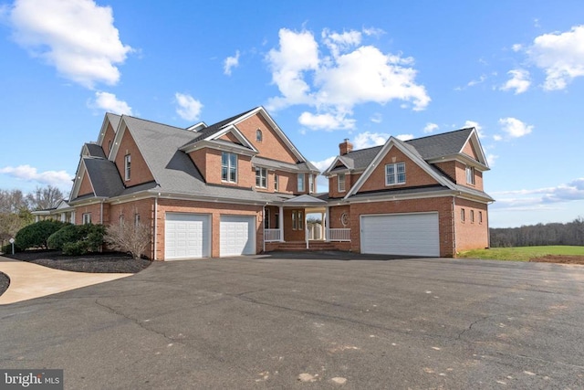view of front of house with an attached garage, brick siding, and driveway