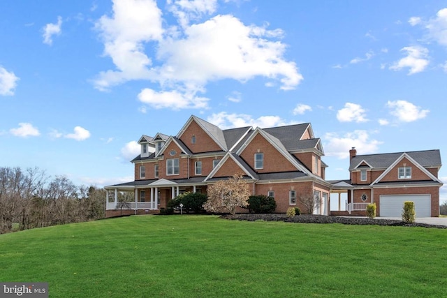 view of front of home featuring covered porch, a front lawn, a garage, and driveway