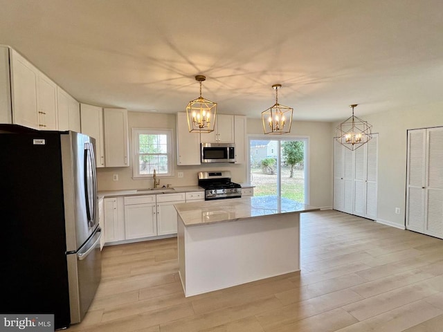 377 Cleveland St, Warrenton, VA 20186 - kitchen with stainless steel appliances, a chandelier, white cabinetry, and light wood-type flooring