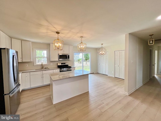 377 Cleveland St, Warrenton, VA 20186 - kitchen featuring stainless steel appliances, a chandelier, white cabinetry, light wood-style floors, and light countertops