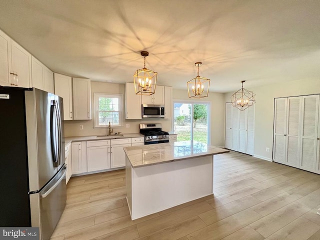 377 Cleveland St, Warrenton, VA 20186 - kitchen with appliances with stainless steel finishes, a chandelier, light wood-style flooring, and white cabinetry