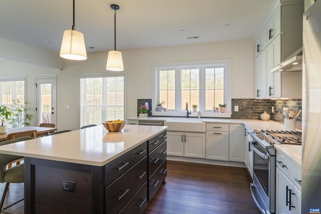 4017 Marie Curie Ct, Charlottesville, VA 22902 - kitchen featuring stainless steel range with gas cooktop, range hood, light countertops, a breakfast bar, and white cabinets