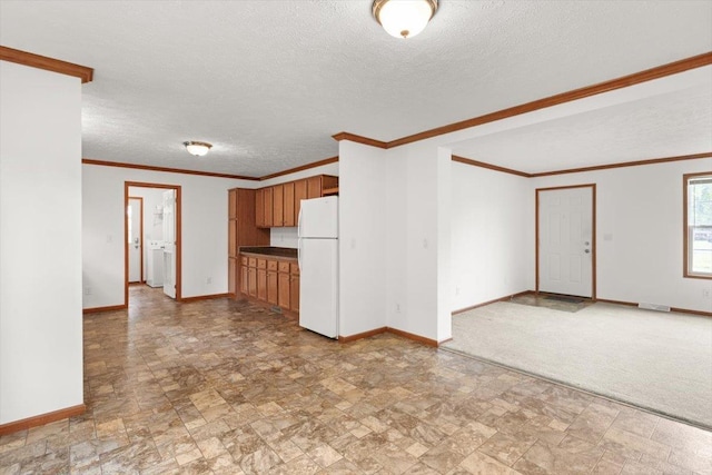 4767 Ox Rd S, Edinburg, VA 22824 - kitchen featuring freestanding refrigerator, stone finish flooring, brown cabinetry, a textured ceiling, and crown molding
