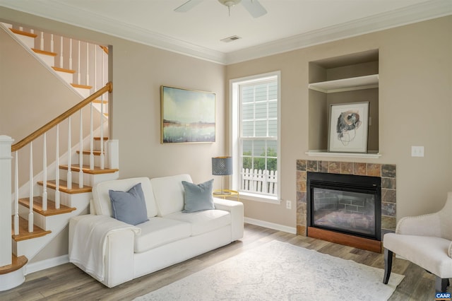 1875 Clay Dr, Crozet, VA 22932 - living room featuring wood finished floors, crown molding, ceiling fan, stairway, and a tiled fireplace