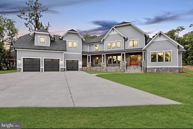 view of front of house featuring a porch, a garage, and a lawn