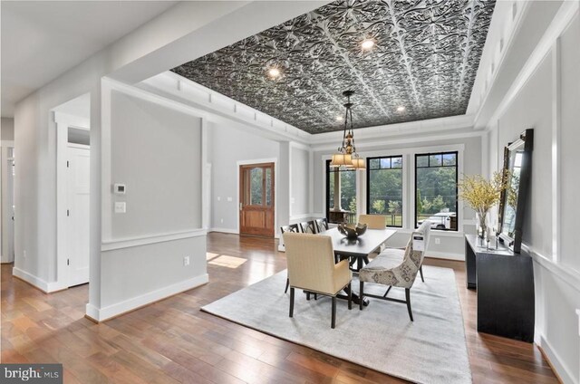 dining space featuring a tray ceiling and hardwood / wood-style flooring