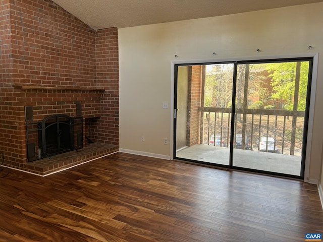 125 Turtle Creek Rd Unit 9, Charlottesville, VA 22901 - unfurnished living room with lofted ceiling, wood finished floors, a brick fireplace, and a textured ceiling