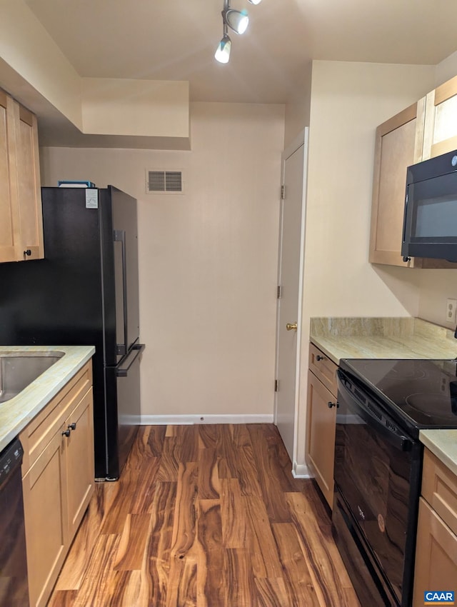 125 Turtle Creek Rd Unit 9, Charlottesville, VA 22901 - kitchen featuring black appliances, wood finished floors, light countertops, and rail lighting